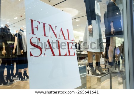 sale poster in fashion shop display window