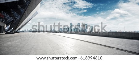 Photo of empty brick floor with cityscape of modern city