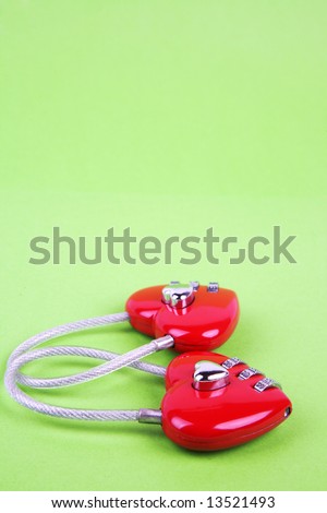 couple of heart shape lock locked up with green background