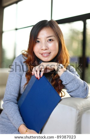 Smiling asian business woman holding with folder in office