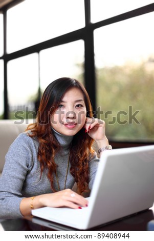 Smiling asian business woman with laptop