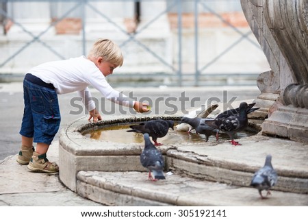 LITTLE BOY FEEDING BIRDS