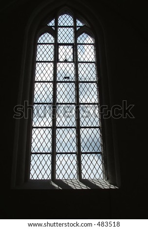 Sunlight falling through a gothic window with stained glass
