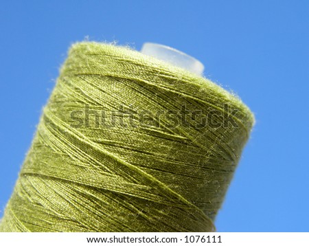 Close-up of green yarn cone against clear blue sky