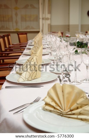 large dinner table set up for a lot of people - focus on second couvert