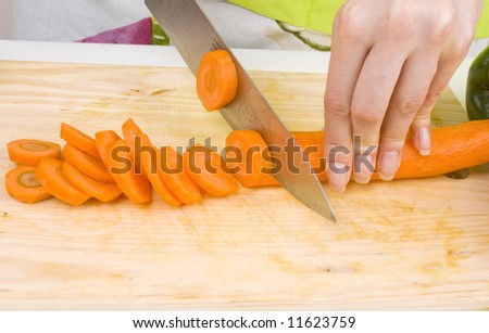 close-up of woman cutting carrots; preparing food