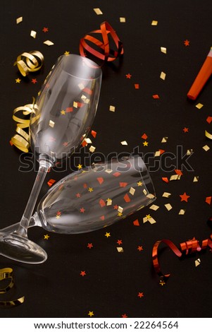 Holiday background; ribbons, colorful confetti stars and Champagne glasses  on a table