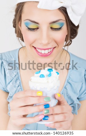 Pin-up girl with colorful makeup and manicure holding ice-cream