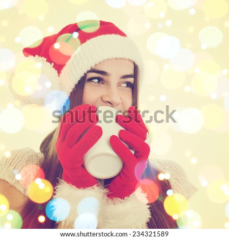 Closeup of cute young Christmas woman drinking tea. Teenage girl with Santa Claus hat and gloves drinking from big white mug. Square format. Colorful bokeh effect.