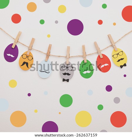 Colorful Easter eggs and dots wall decoration. Modern colorful printed hipster eggs decoration with mustaches and glasses. Square format, matte instagram look filter.