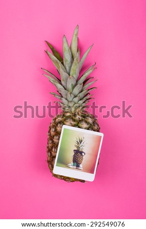 Pineapple and photograph print of pineapple with glasses and crochet shoes against pink background. Vertical, no retouch.