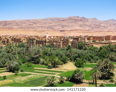 Landscape of a desert kasbah with green oasis.