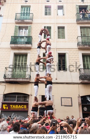 BARCELONA, SPAIN - AUGUST 17:  Group of people makes human tower in Festes de Gracia, Barcelona. Catalan human towers are on UNESCO's Cultural Heritage List. August 17, 2014 Barcelona.