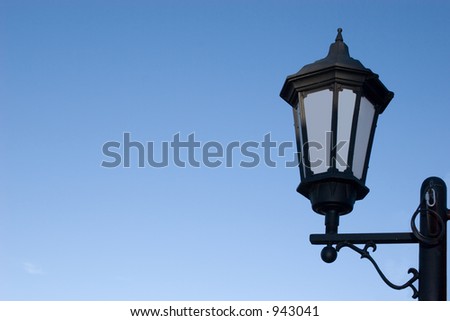 A classic lamp post against an isolated blue sky for design work