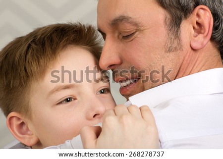 Close-up shot of an emotional embrace of son and father. Happy and close-knit family