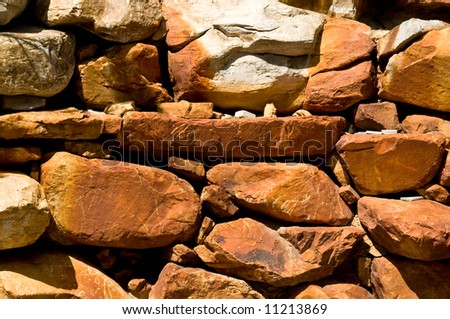 vivid red rocks stacked in a landscaping wall