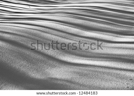 shadows fall in rippling lines across a rolling black and white snowscape
