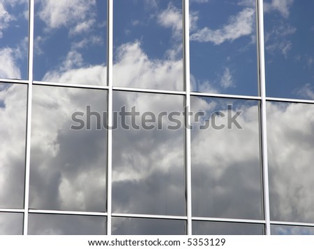 Reflection of clouds in mirror glass windows of a building