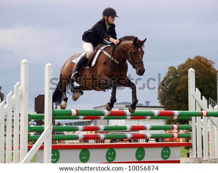 A show jumper over the top of a jump