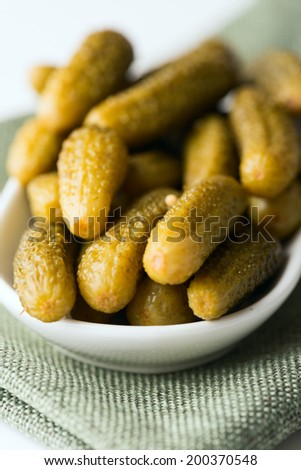 Dill pickles in bowl in soft focus. Macro with shallow dof.