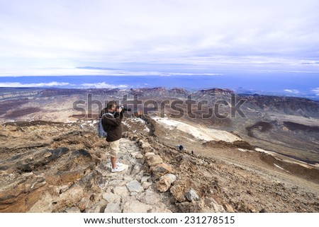 Man at  top of volcano Teide with blue sky. Teide is the highest volcano in Europe (Teide National Park, Tenerife, Canary islands, Spain).
