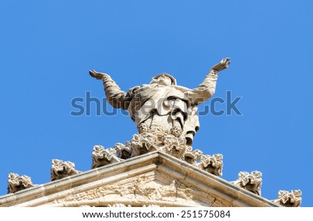 Details of roof church facade in Spain. Praying woman statue.
