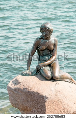 COPENHAGEN, DENMARK, MAY 18: Little Mermaid is a bronze statue by Edvard Eriksen, depicting a mermaid on May 18, 2013. Sculpture is displayed on a rock by the waterside at the Langelinie promenade.