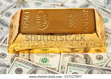 Closeup of golden  bullion on hundred dollars banknotes background