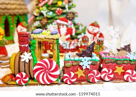 Happy gingerbread people gathered by the christmas tree looking at train as Christmas fun decoration
