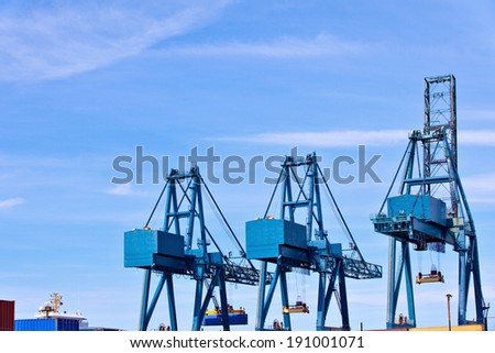 Blue cargo cranes at Sea port against sky background