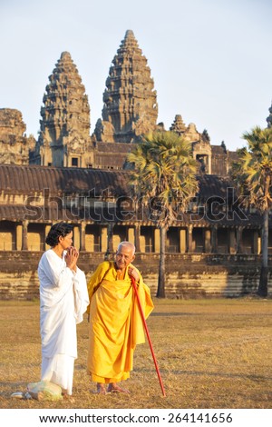 ANGKOR WAT, KRONG SIEM REAP, SIEM REAP, CAMBODIA-JANUARY 5, 2015: Two unidentified old buddhist female monks dressed in yellow and white togas talking at Angkor Wat temple.