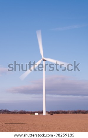 Single wind turbine vertical showing motion blur of the moving blades