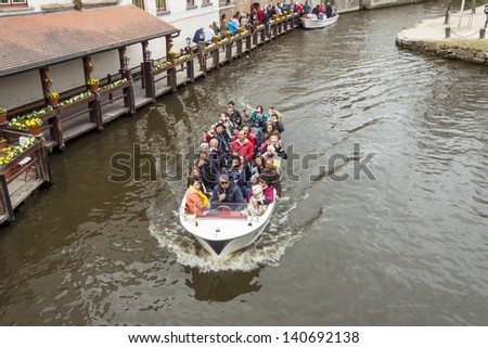 BRUGGE, BELGIUM - APRIL 22: Boat tour into the canals of Old UNESCO town on april 22, 2013 in Burgge. Bruges is frequently referred to as \