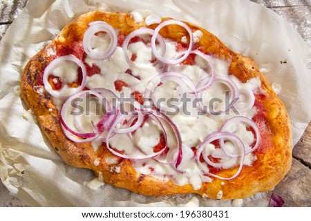Freshly baked pizza with red onion and mozzarella