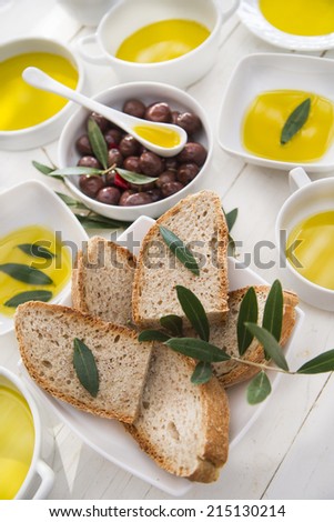 Presentation of wholemeal bread and olives with olive oil