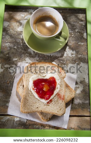 presentation of a breakfast of coffee, bread, butter and jam
