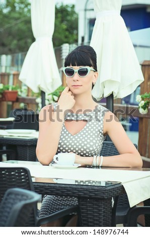 vintage beautiful woman in restaurant cafe with coffee.Breakfast time.Stylish rich slim girl in retro dress.glamorous lady at vacation. Retro style.Audrey Hepburn style.series