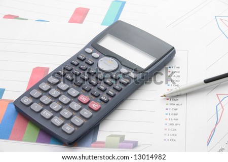 A bar graphs and calculator and pen on it.