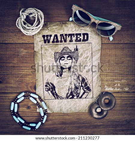 Accessories cowboy retro style on wooden surface with wanted poster. glasses, necklace, earrings