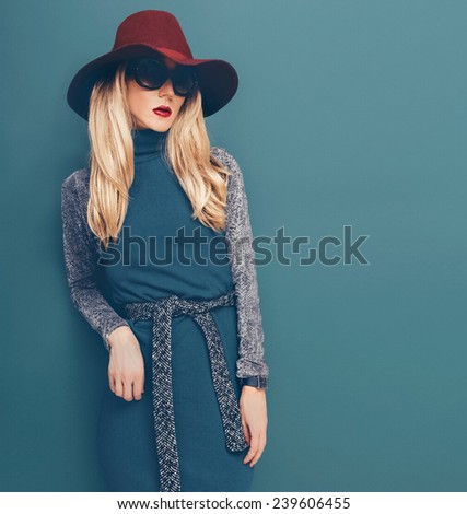 Glamorous Blond model in vintage Hat and Dress on green background