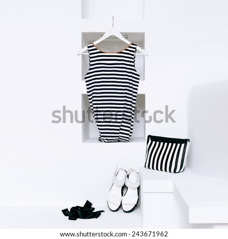 Marine style fashion. Women\'s clothing in white interior. trend strip