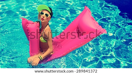 Glamour Girl with inflatable mattress in the Pool.  Hot Summer party