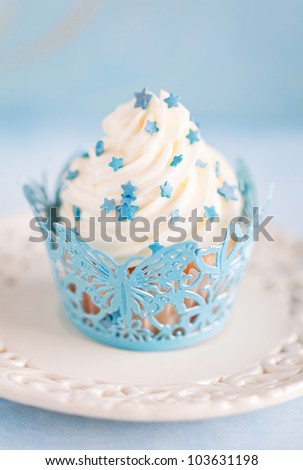 Cupcake with cream and blue decor, selective focus