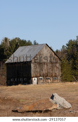 Old Barn with Farmyard with provincial park as background. This is just outside of Algonquin Provincial Park in Ontario, Canada