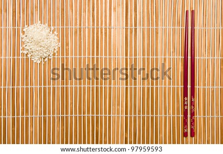 Chopsticks and rice over a place mat