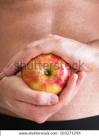 Muscle sexy wet naked young man torso and red apple in hands diet