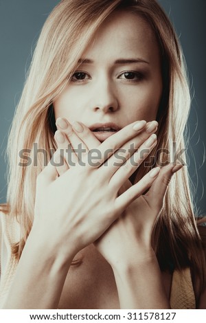 Speak no evil concept. Surprised woman face covering her mouth with hands close up
