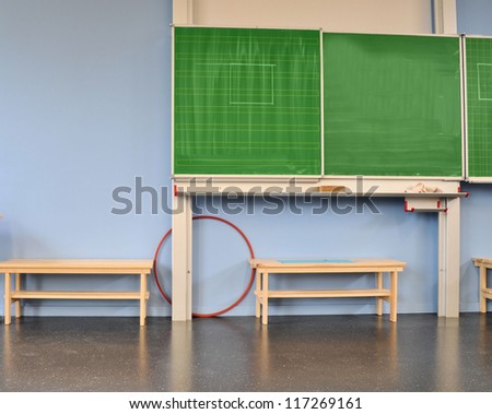 Green blackboard, furniture and floor in a school
