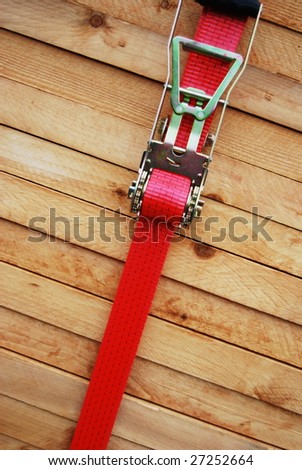Red lashing strap on a pile of timber