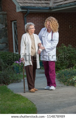 Nurse Helping Senior Walking with Cane Outdoor in Early Morning Outside House